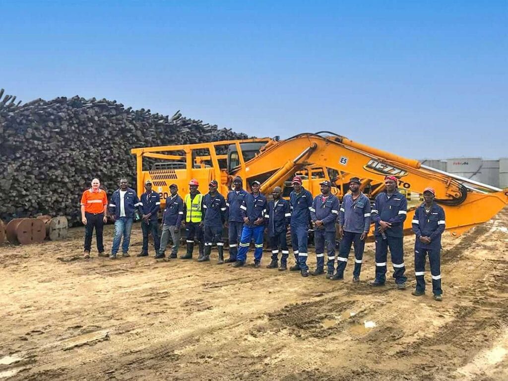 Moz Fibra Team in front of a Pulp Wood Log Pile at Beira Port site